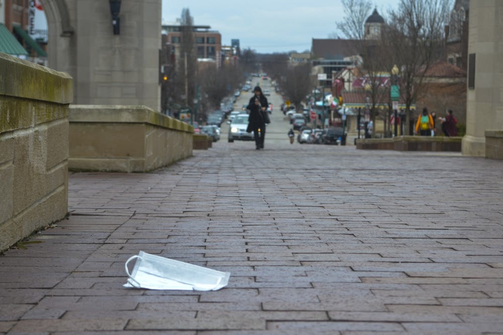 <p>A surgical mask rests on the ground March 12 in front of Sample Gates. All IU summer events through July 31 have been canceled due to the coronavirus pandemic. </p>