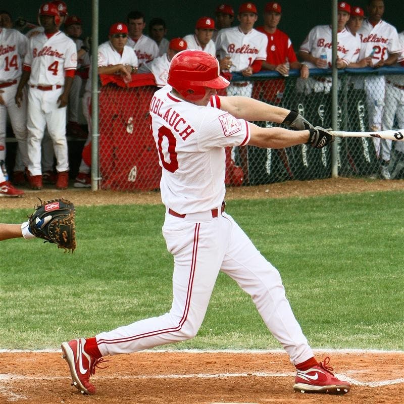 IU baseball recruit Trace Knoblauch takes a swing at the ball Feb. 27th while his teammates look on from the dugout. Knoblauch is considered one of the top players in Texas and has deep roots in baseball due to his family's involvement in the sport.