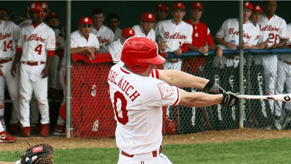 IU baseball recruit Trace Knoblauch takes a swing at the ball Feb. 27th while his teammates look on from the dugout. Knoblauch is considered one of the top players in Texas and has deep roots in baseball due to his family's involvement in the sport.
