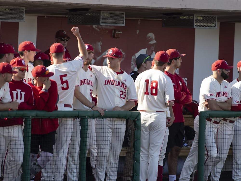 The IU baseball team cheers and watches the game March 27 at Bart Kaufman Field. IU lost to Kent State University, 9-8.