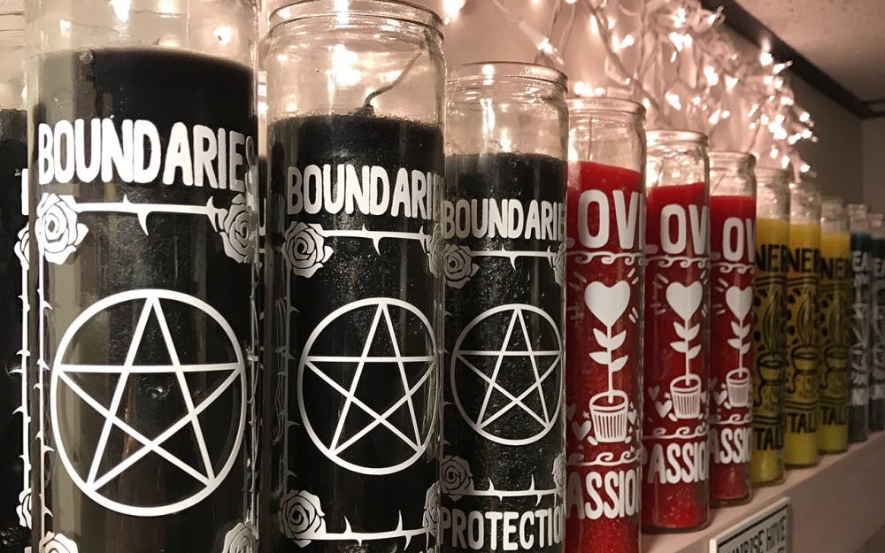 Homemade ritual candles line the walls of Sunrise Hive. Members of the Sunrise Hive community often gather to decorate candles with magical symbols, owner Daun Fields said.