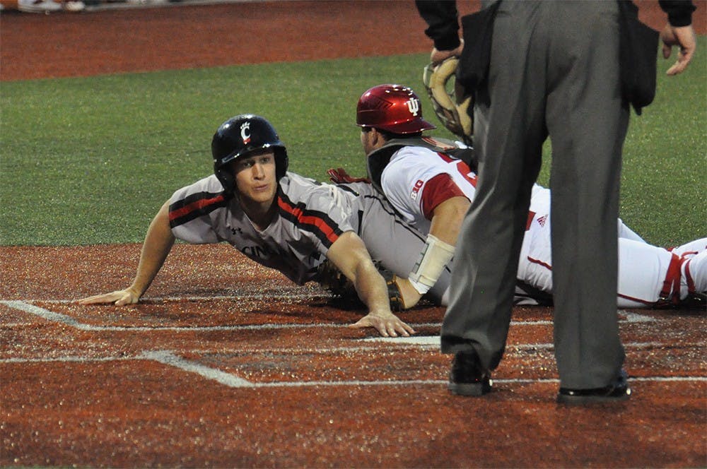 IU catcher Ryan Fineman attempts to tag out Cincinnati player Treg Haberkorn during the 8th inning. IU lost 5-0 Tuesday at Bart Kaufman Field. 