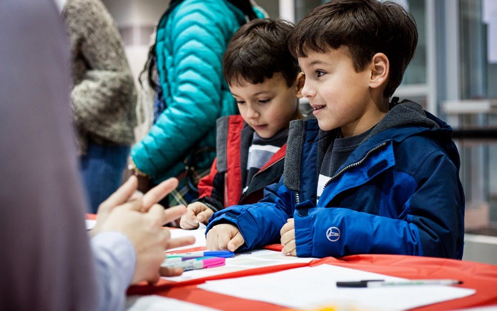 A young boy and his brother sign in for the MLK Birthday Celebration. The community teach-in, for both children and their families, took place&nbsp;Sunday in the IU School of Education. The celebration included coloring activities, a musical performance, an interactive discussion and a celebratory birthday cake.