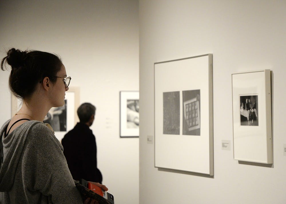 Sophomore Annie Conyngham looks at the photos from A Shared Gallery exhibit. The photography exhibit took place Tuesday at the Grunwald Gallery of Art.&nbsp;