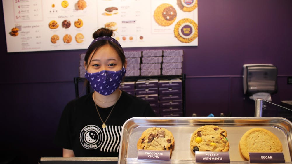 IU sophomore Hannah Lim works behind the counter at Insomnia Cookies on Saturday. The store opened March 1, but celebrated its grand opening Saturday offering special deals.