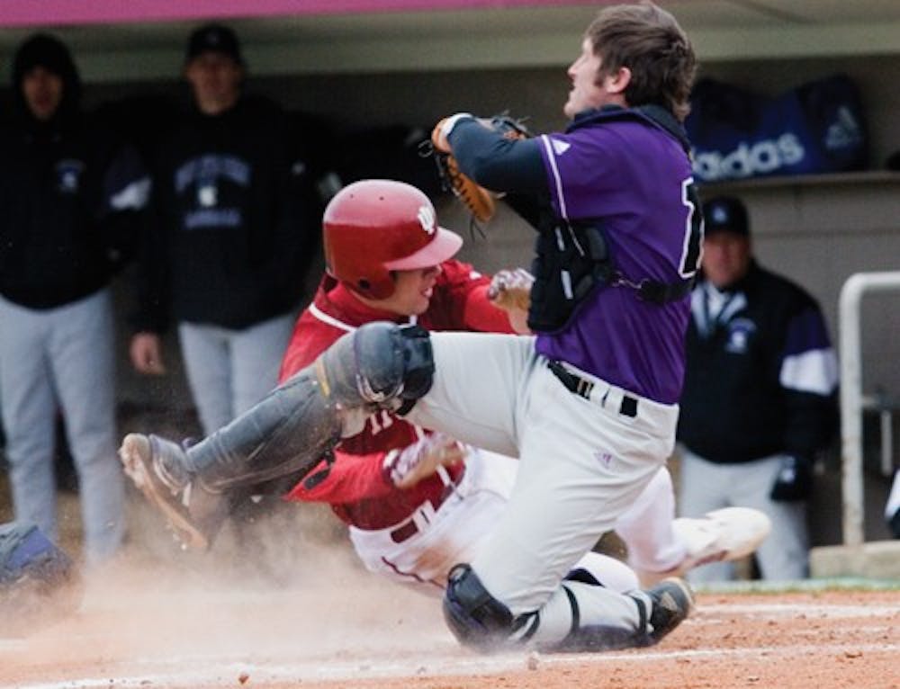 Sophomore outfielder Andrew Means slams into a Northwestern catcher during the second game of a double-header Sunday at Sembower Field.  The Hoosiers lost both games.