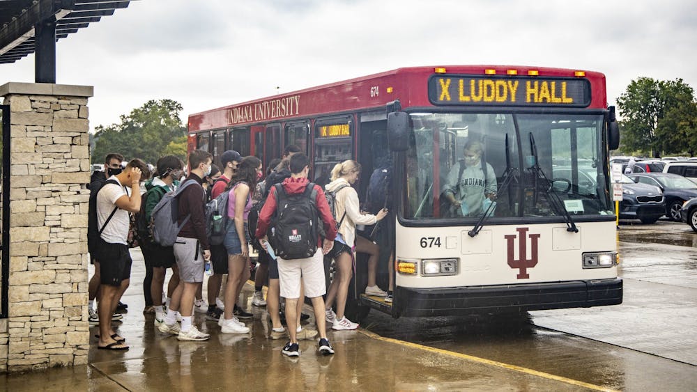 学生们在纪念体育场30,2021年8月30日的X路线巴士。学生们经历过校园巴士服务的延长巴士延误。