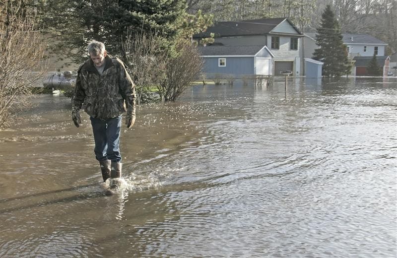 Steve Clark walks back after checking on his home as the Tippecanoe River still rises Wednesday, March 11, 2009, near Delphi, Ind. Clark left his home early Wednesday morning after the water rose too high. 