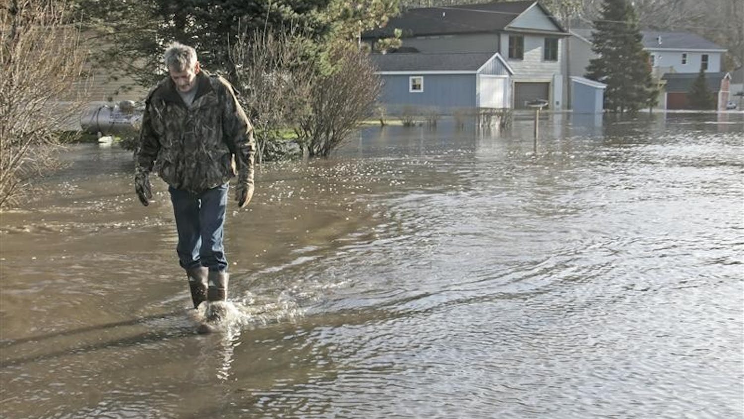 Steve Clark walks back after checking on his home as the Tippecanoe River still rises Wednesday, March 11, 2009, near Delphi, Ind. Clark left his home early Wednesday morning after the water rose too high. 