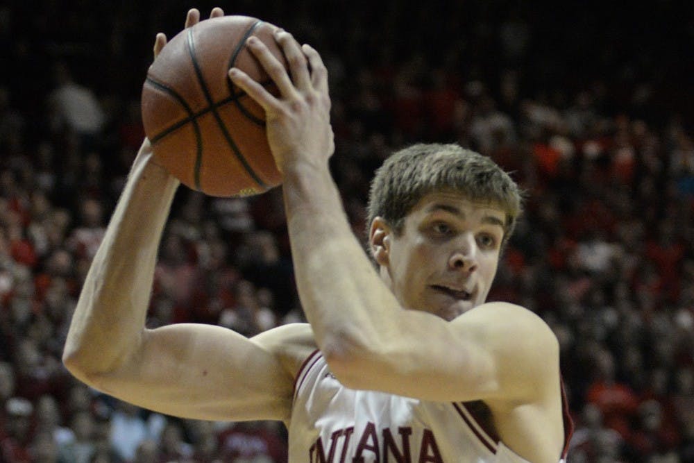 <p>Sophomore Collin Hartman grabs a rebound late in IU's game against Ohio State on Saturday at Assembly Hall.</p>