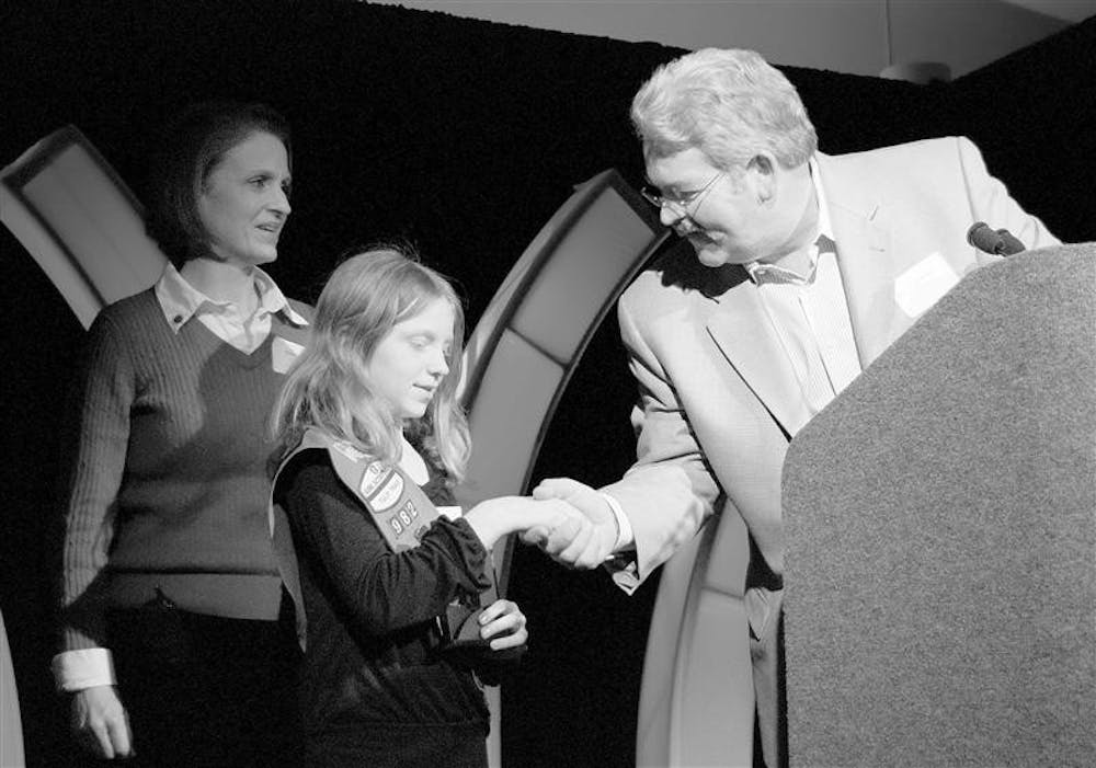 Tutto Bene owner Craig Widen, right, presents the Volunteer Award to Kate Perry, center, and her family during Downtown Bloomington Incorporated’s annual meeting and award ceremony Thursday afternoon at the convention center. The Perry family won for its support of the annual Downtown Easter Egg Hunt.