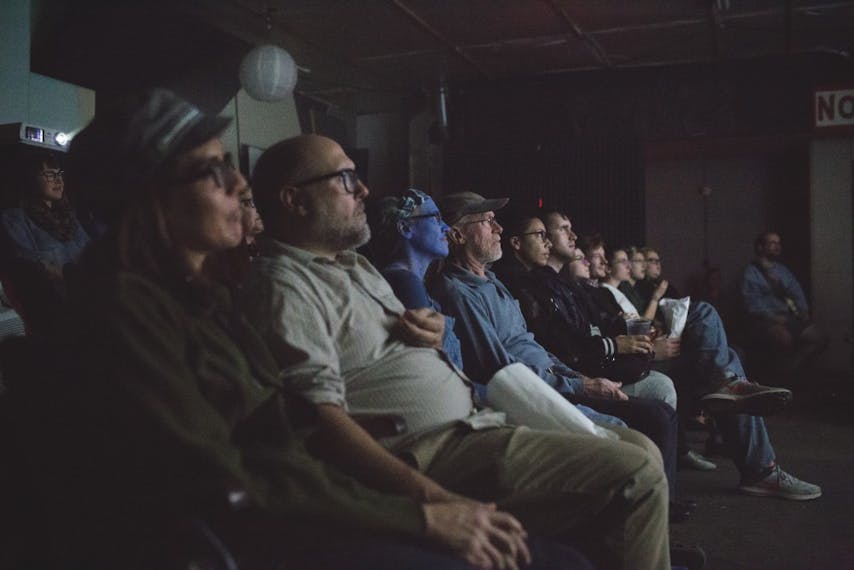 Patrons of a Cicada Cinema film event watch a film. Cicada Cinema is a pop-up cinema collective based in Bloomington.