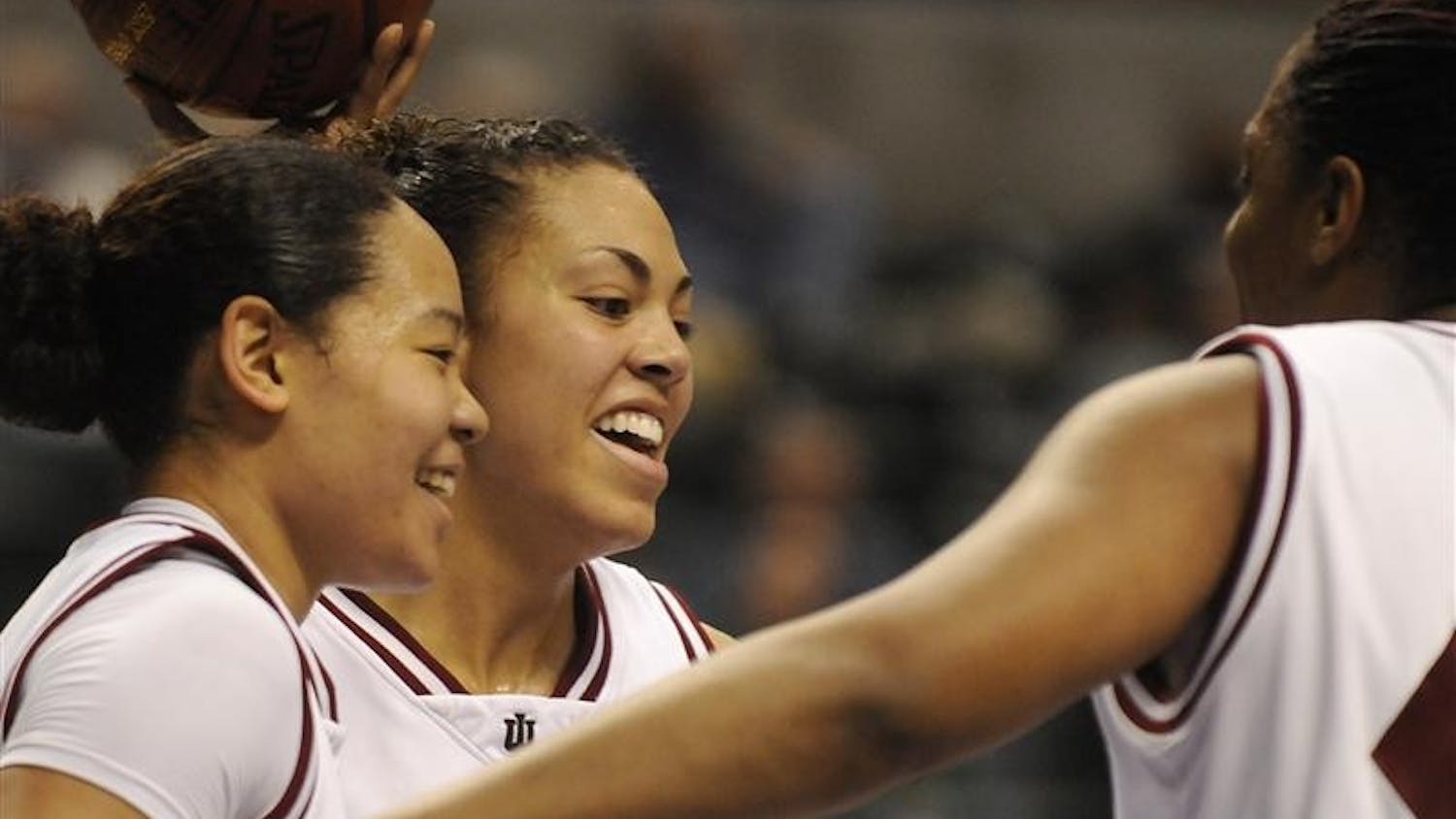 IU seniors Kim Roberson, left, Whitney Thomas and Amber Jackson share a laugh during the closing minutes of IU's 68-50 win against Michigan in the first round of the Big Ten Tournament on Thursday at Conseco Fieldhouse in Indianapolis.