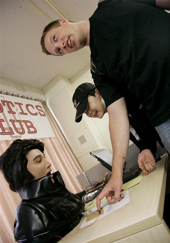 First-year graduate students Michael Potter and Farkhat Yussupjanov test an Elvis robot Friday afternoon at the Robotics Club Open House in Eigenmann Hall. The robot had 16 degrees of freedom, and allowed people to play with the expression of the robot by pushing various buttons.