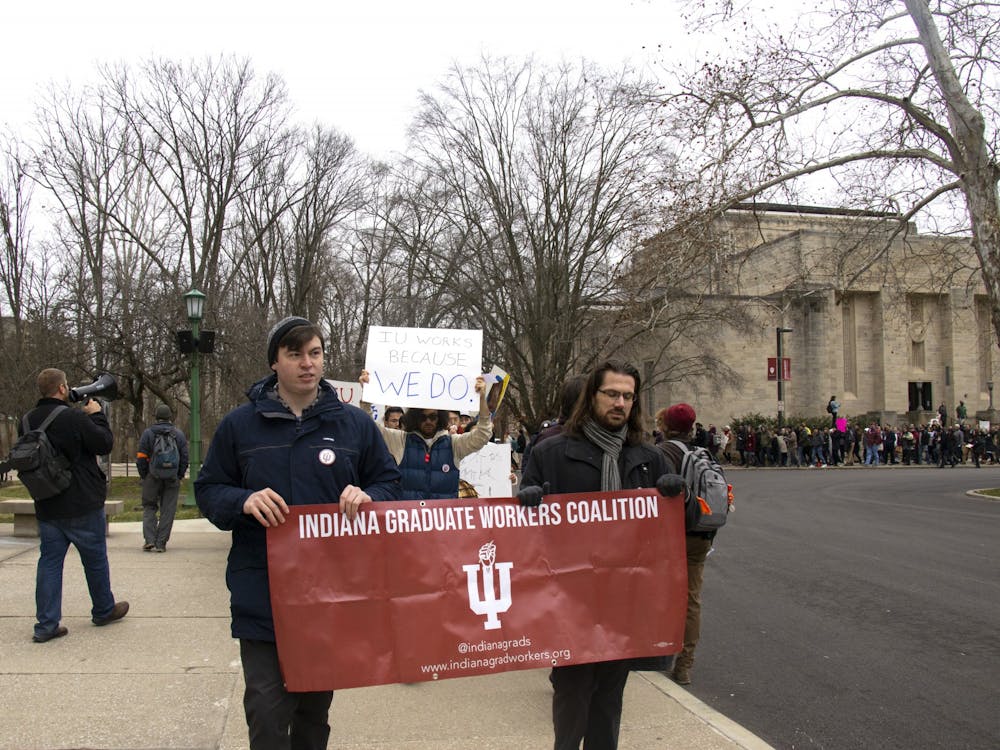 Participants walk Jan. 28 to Herman B Wells Library during a graduate student march.