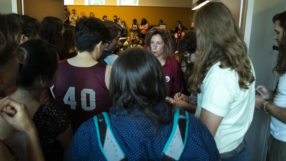 Students listen from the hallway at the Indiana University Graduate Workers Coalition town hall meeting Sept. 12 at the Lee Norvelle Theatre and Drama Center. Indiana Graduate Workers Coalition, a student-led organization protesting conditions for IU graduate students, organized the event.