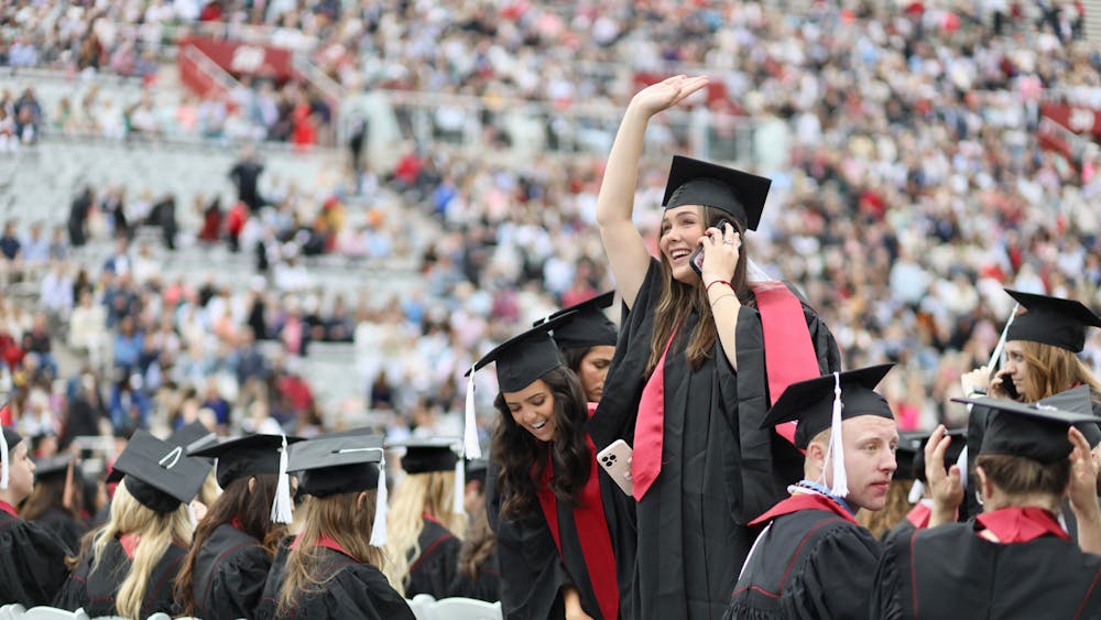 A student waves to friends and family before the 194th undergraduate commencement. IU honored more than 20,000 graduates in total across the state.﻿