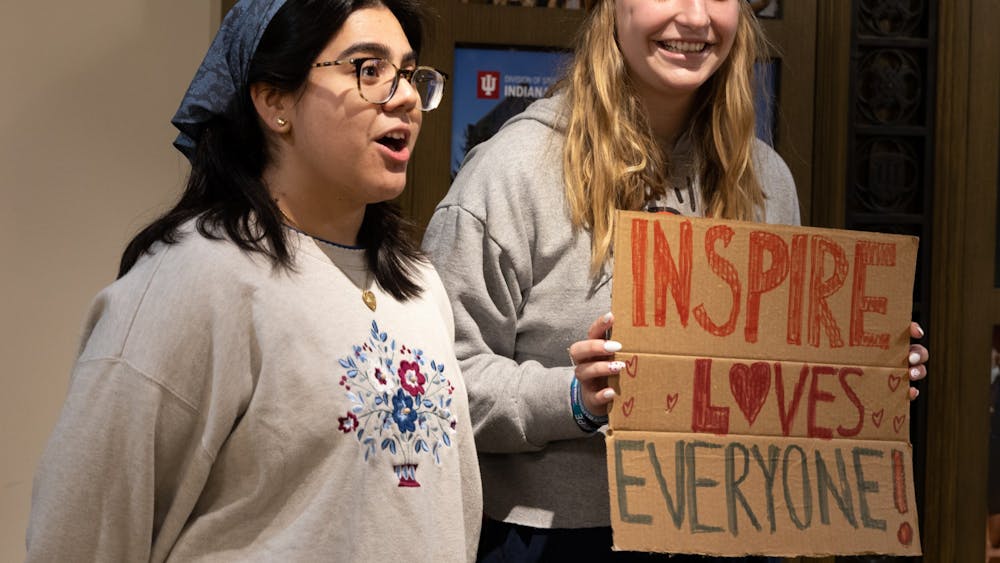 Students Ava Roblero and Quinn Sever show off their sign Feb. 2, 2023, outside the Whittenberger Auditorium. The students were representatives of the Inspire LLC and came to the event to support the community as future educators.