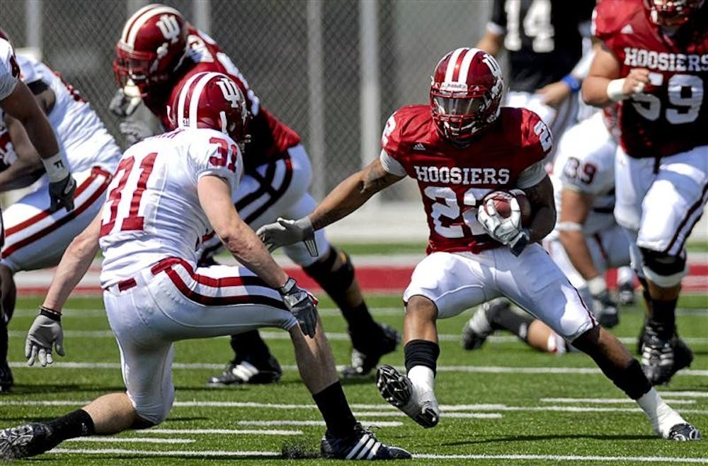 Running back Darius Willis tries to evade safety Kyle Detrick during the Spring Game on Saturday afternoon at Memorial Stadium. The Crimson team won 28-27.