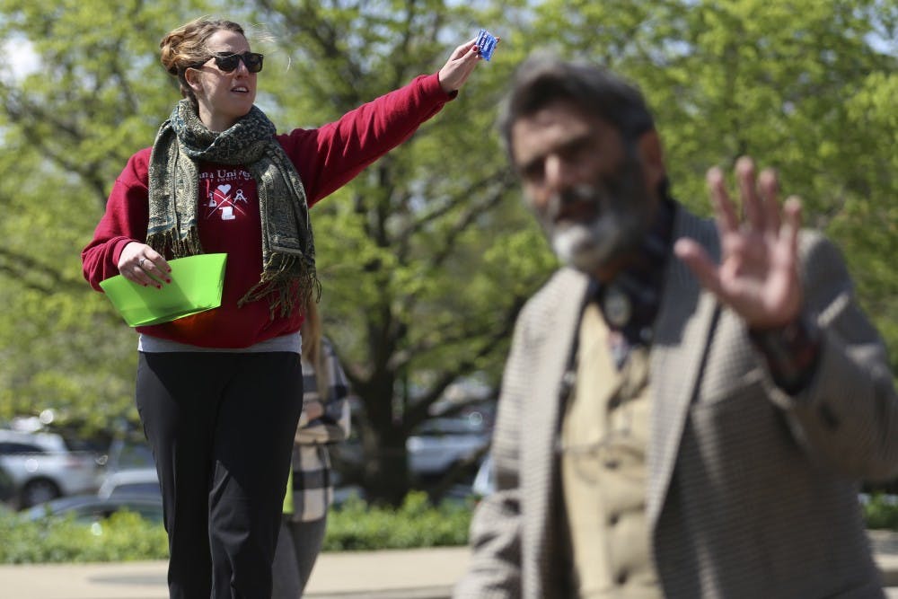 Junior Sarah Huston of R.A.I.S.E. (Raising Awareness of Interactions in Sexual Encounters) hands out free condoms on campus by Brother Jed as he preaches and condemns the crowd. The condoms were originally meant to be handed out because of upcoming Little 500, but when Brother Jed showed up, the group changd course. Huston said they're promoting safe sex and the idea that someone's "not a whore" for having sex.
