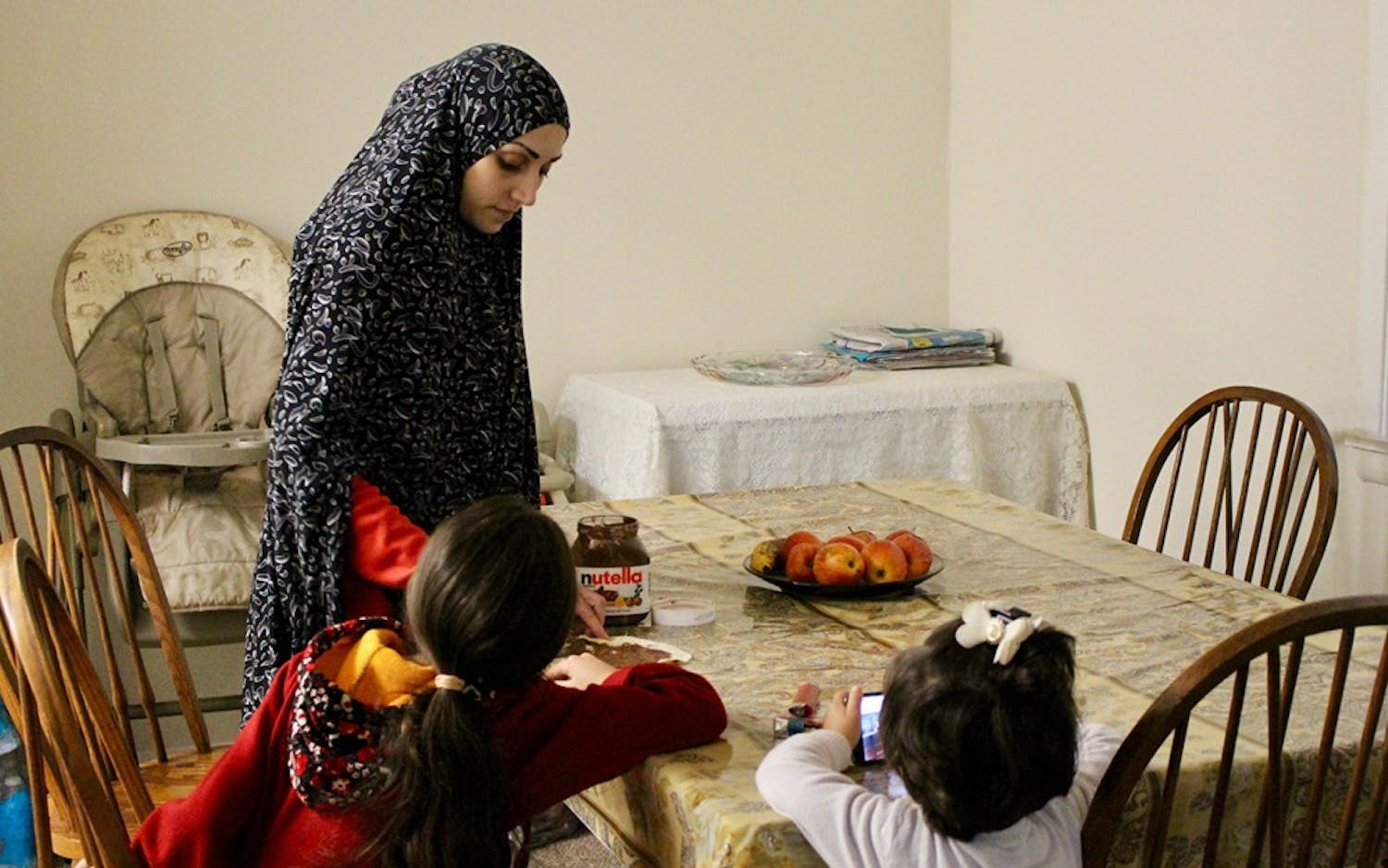 Duha Lababidi fixes her daughter Sara, 7, an afternoon snack. The Lababidi family has been living&nbsp;in Indianapolis since December after being resettled from Syria by way of Jordan.&nbsp;