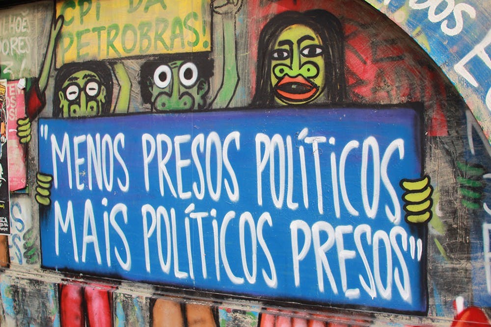 Graffiti belonging to the Brazilian protest group Black Bloc covers a wall near São Paulo's central avenue. The words imply that corrupt politicians ought to be blamed and imprisoned for corruption instead of young protestors who are often arrested by the federal police.