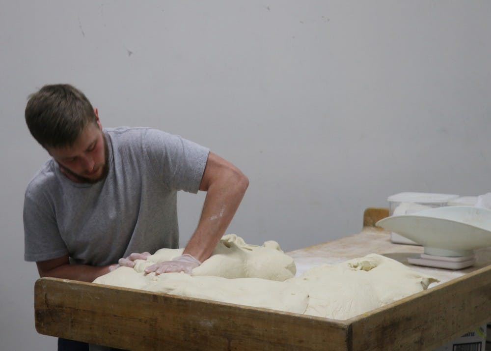 Ratts presses plain bagel dough on the table. As the dough is removed from the mixer it is placed on the table where it is hand-pressed into one large slab.&nbsp;