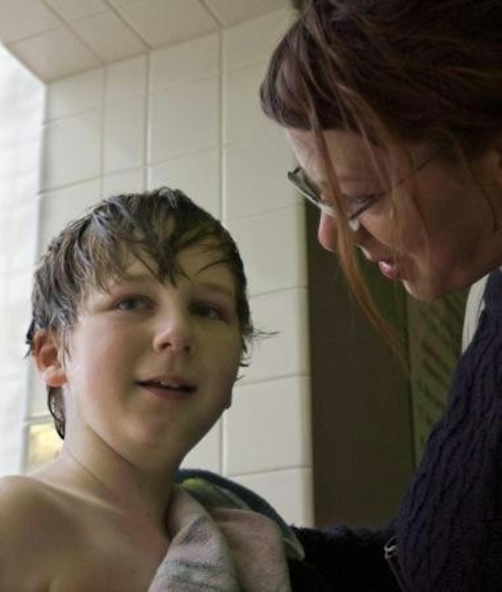 Krista Robinson helps her son, Ezra, dry off after his adapted swimming class at the Monroe County YMCA.