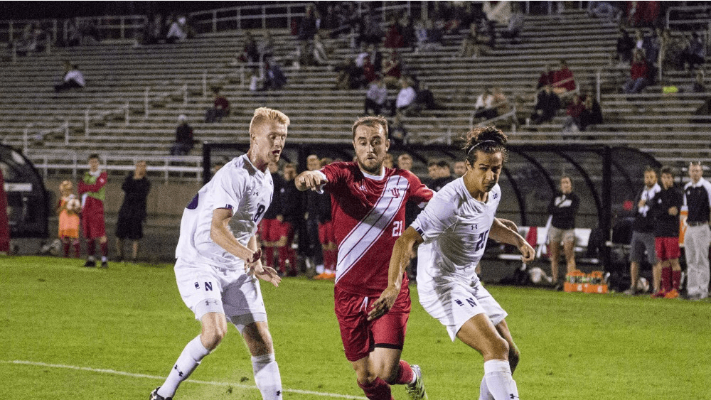Sophomore Spencer Glass, center, runs the ball through Northwestern players Mac Mazzola, left, and Julian Zighelboim, right, Sept. 26 at Bill Armstrong Stadium. Glass’ run resulted in IU’s second goal of the night with Griffin Dorsey connecting with the ball in front of net to finish the game against NU, 2-1.