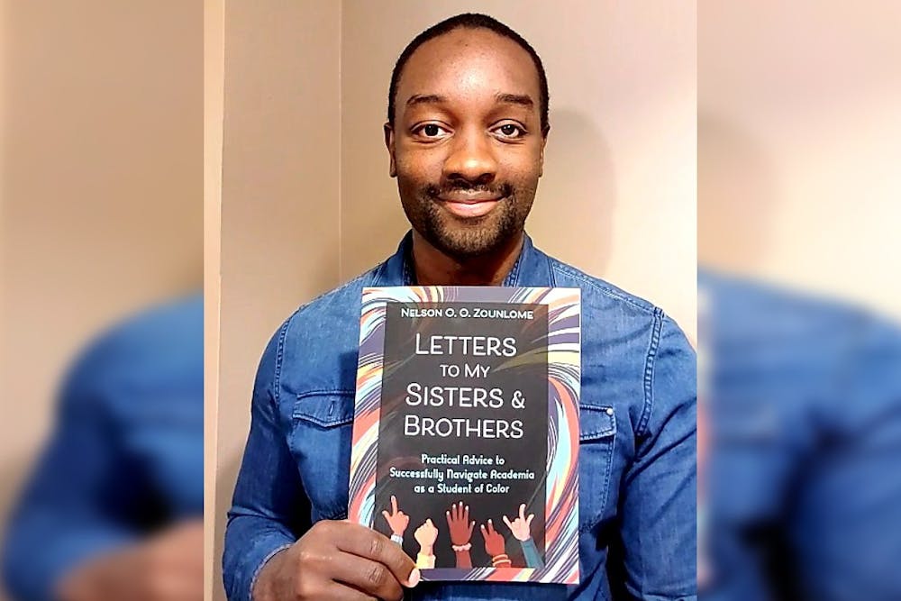 印第安纳大学研究生Nelson Zounlome与他的书《给我的姐妹和兄弟的信:作为有色学生成功导航学术界的实用建议》合影。大约两年前，他开始写这本书，为黑人、土著和其他有色人种学生创建一个资源