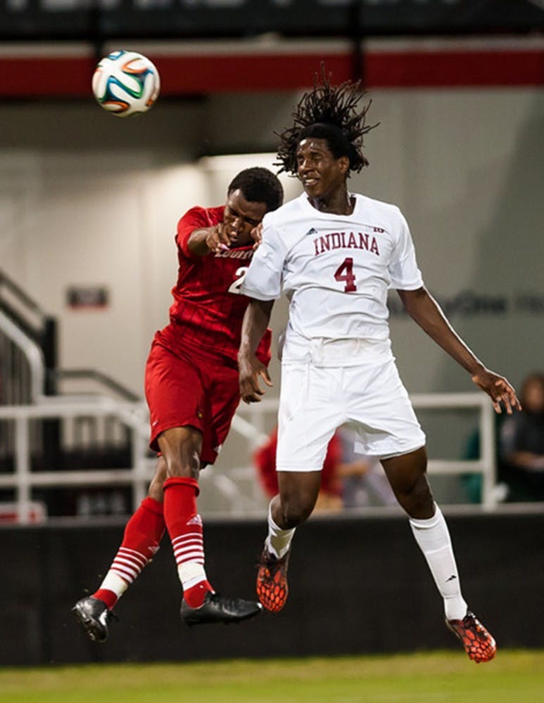 Junior Femi Hollinger-Janzen fights for the ball against Louisville's Michael DeGraffenreidt during IU's game against the Cardinals on Tuesday at Lynn Stadium in Louisville, Ky.