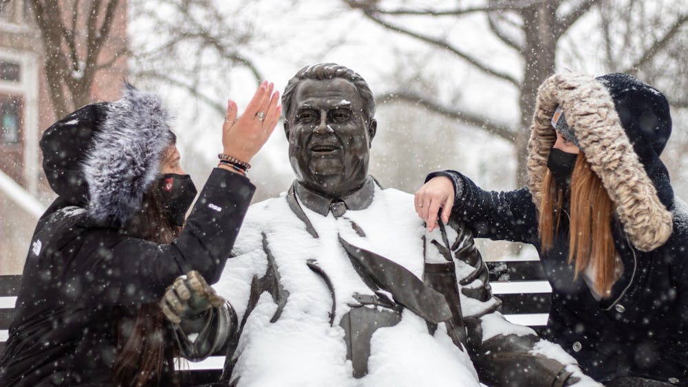Freshmen Madeline Herman and Emma Gagnon chat at the Herman B﻿ Wells statue. Bloomington is expected to receive 3 to 7 inches of snow Jan. 25, 2023.