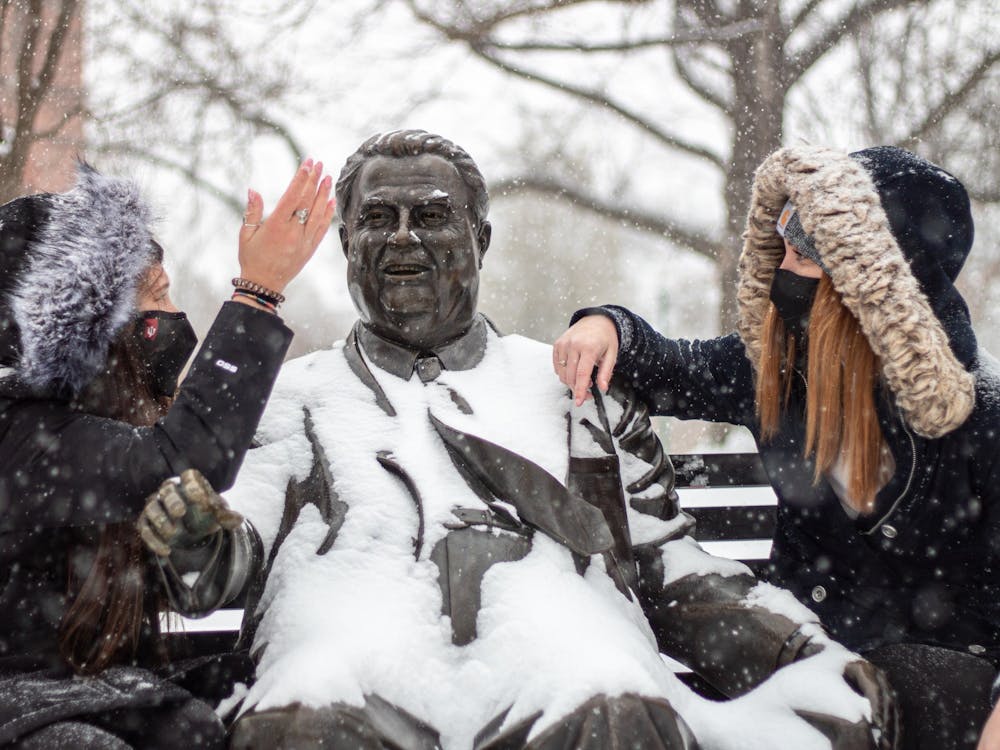 Freshmen Madeline Herman and Emma Gagnon chat at the Herman B﻿ Wells statue. Bloomington is expected to receive 3 to 7 inches of snow Jan. 25, 2023.