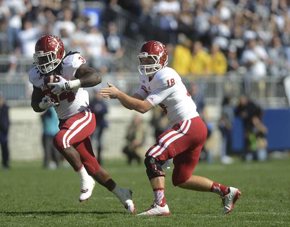 Quarterback Danny Cameron hands off the ball to running back Devine Redding during the game against Penn State on Saturday at Beaver Stadium in University Park. The Hoosiers lost, 7-29.