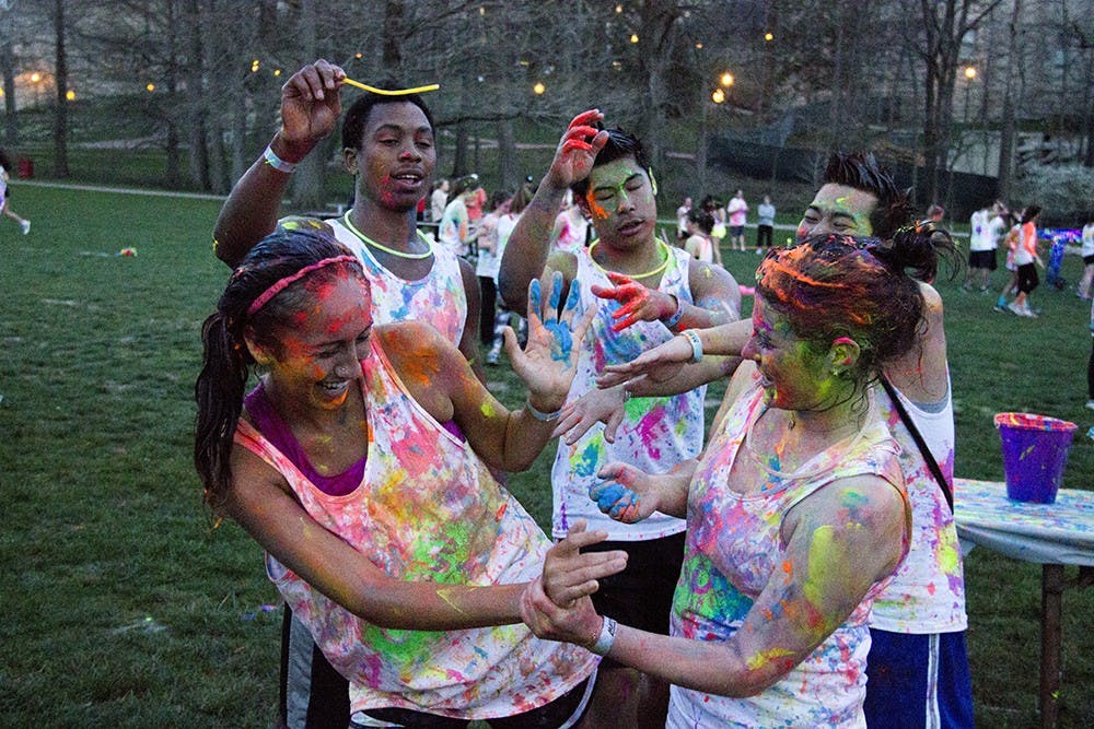Students spray glow paint on eachother during GlowRun sponsored by Timmy Global Health at Dunn Meadow on April 17, 2014.