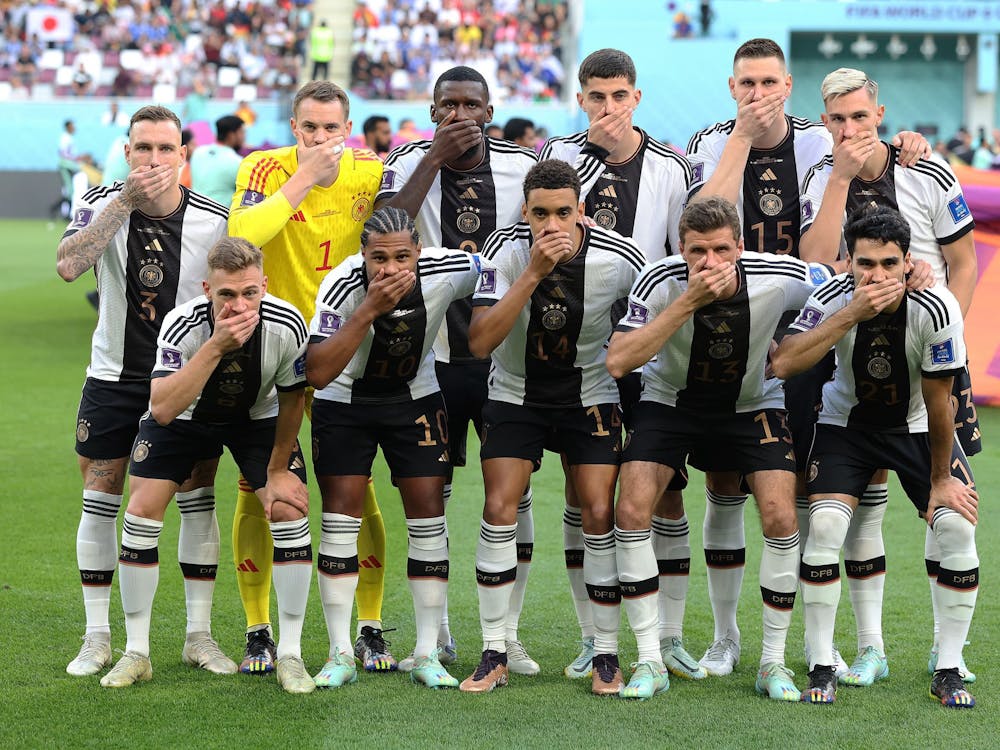 Germany players pose with their hands covering their mouths as they line up for team photos prior to the FIFA World Cup Qatar 2022 Group E match between Germany and Japan Nov. 23, 2022, at Khalifa International Stadium in Doha, Qatar.