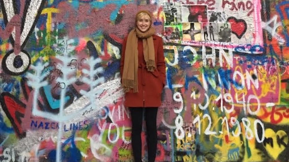 Travel columnist Rachel Rosenstock stands in front of the John Lennon wall in the Malà Strana neighborhood of Prague. Rosenstock visited Prague for three days over the weekend.