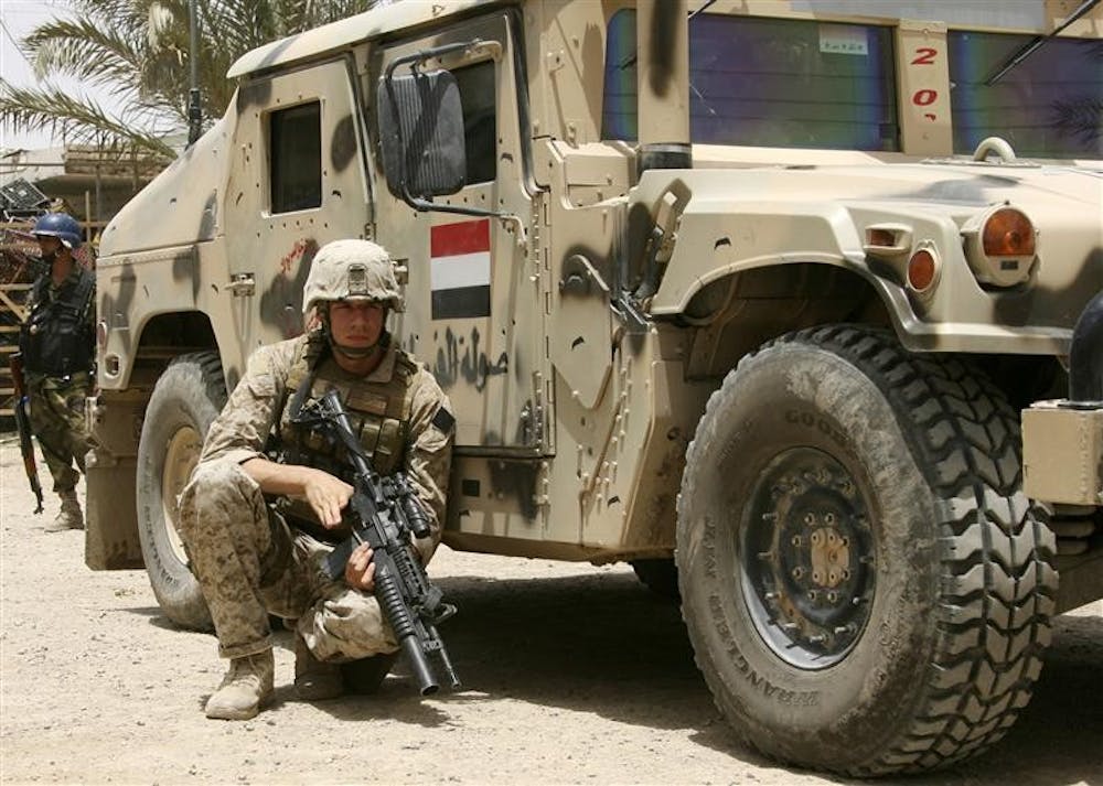 In this Thursday, June 19, 2008 file photo, a U.S. Marine takes cover behind an Iraqi Army humvee during the beginning of combat operations in Amarah, Iraq, 200 miles southeast of Baghdad. The United States will withdraw most of its troops from Iraq by August 2010, 19 months after President Barack Obama's inauguration day, according to administration officials who expect Obama to make the announcement on Friday.