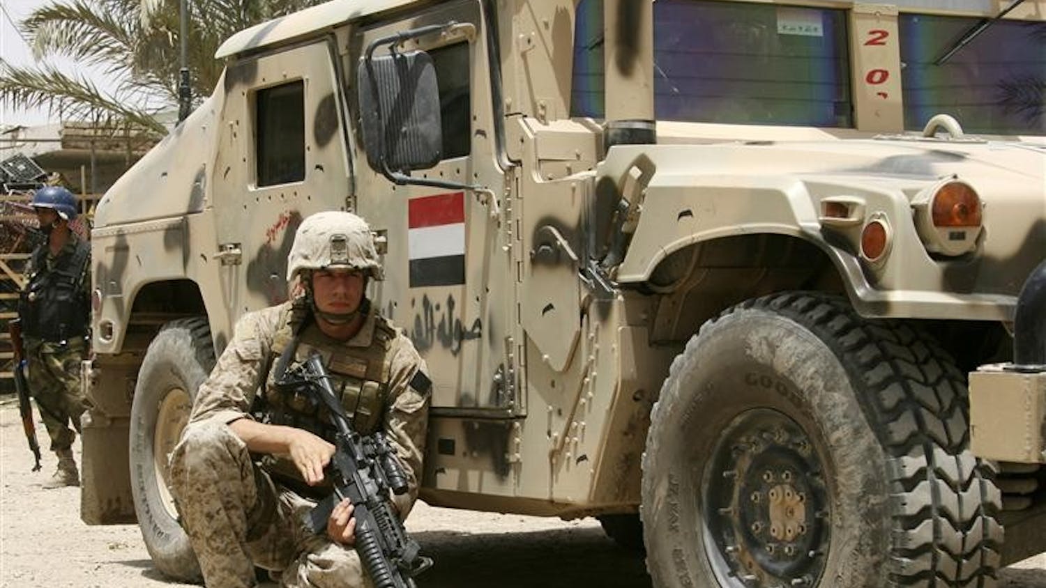 In this Thursday, June 19, 2008 file photo, a U.S. Marine takes cover behind an Iraqi Army humvee during the beginning of combat operations in Amarah, Iraq, 200 miles southeast of Baghdad. The United States will withdraw most of its troops from Iraq by August 2010, 19 months after President Barack Obama's inauguration day, according to administration officials who expect Obama to make the announcement on Friday.
