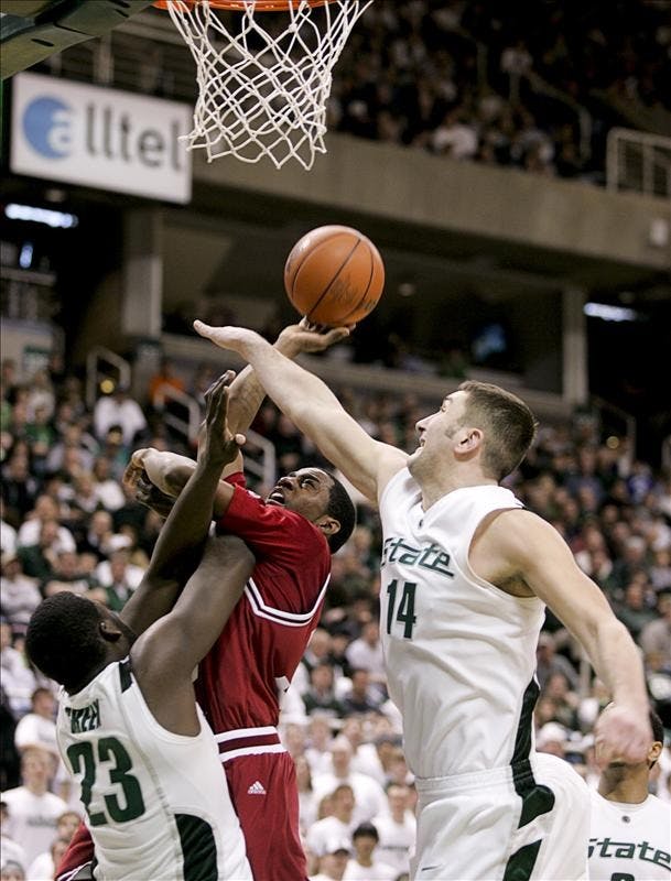 IU junior guard Devan Dumes battles against Michigan State freshman forward Draymond Green (23) and MSU senior center Goran Suton (14) Saturday in East Lansing, Mich..