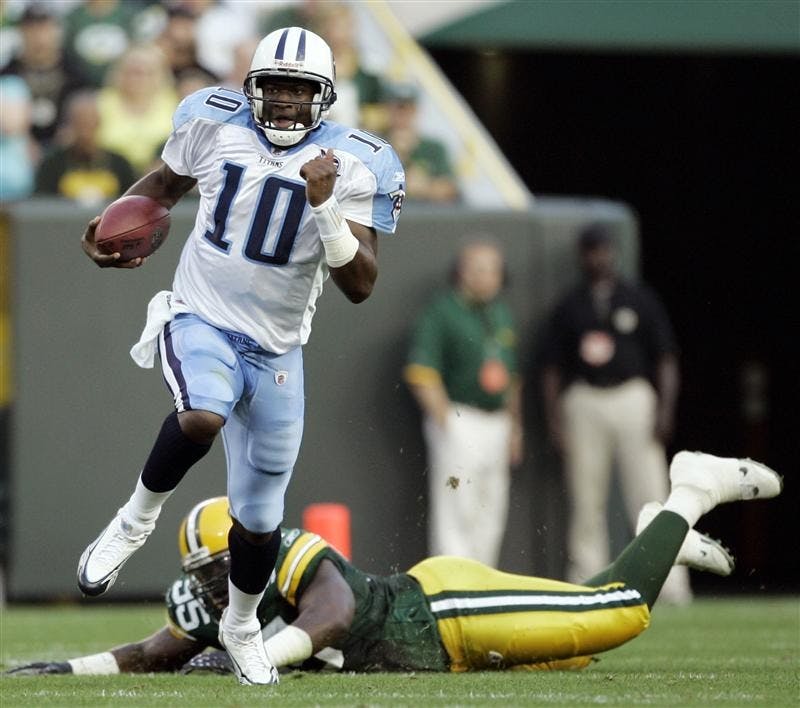 Tennessee Titans quarterback Vince Young (10) breaks away from Green Bay Packers defensive tackle Daniel Muir during the first half of an NFL preseason football game on Thursday in Green Bay, Wis.