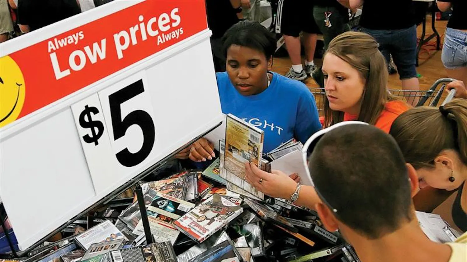 Students rifle through a $5 movie bin during Midnight Madness on Friday night at Wal-Mart. Busses ran continuous shuttles from campus dorms to Wal-Mart from 10 p.m. to 2 a.m. so students could stock up on school supplies and other items.