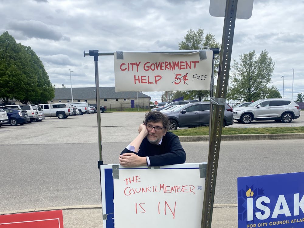 City Council candidate Stephen Volan sits at a makeshift stand advertising free city government help on May 2 at Bloomington High School South. Volan currently represents District 6 — the unofficial student district — but is now running for an at-large seat.