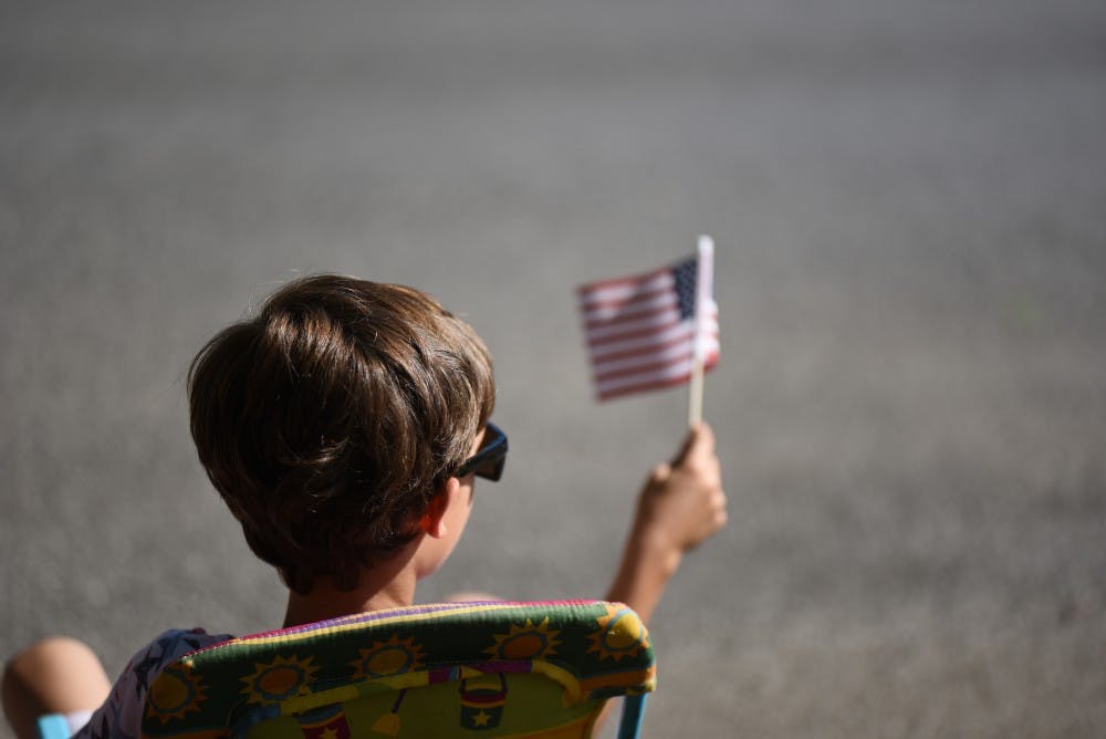 Lyle Henry, nine, waves an American flag during the 4th of July parade. Henry was one of hundreds of children attending the parade to watch and get candy.