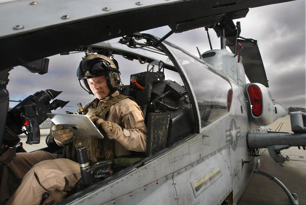 2011年9月1日，在海军陆战队彭德尔顿空军基地，吉姆·卡尔森上尉坐在他的超级眼镜蛇攻击直升机上，手持iPad电脑。美国军方昨晚在布卢明顿从晚上7点到凌晨3点进行了训练，包括军用直升机的飞行。