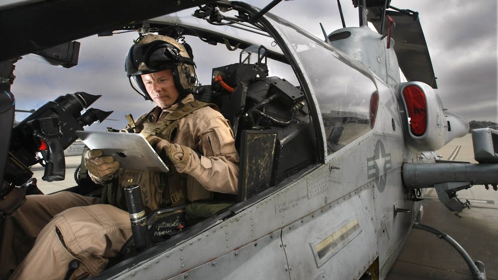 2011年9月1日，在海军陆战队彭德尔顿空军基地，吉姆·卡尔森上尉坐在他的超级眼镜蛇攻击直升机上，手持iPad电脑。美国军方昨晚从晚上7点到凌晨3点在布卢明顿进行了训练，包括军用直升机的飞行。
