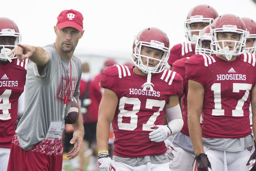 Offensive coordinator Kevin Johns talks receiver Mitchell Paige, as well as other members of the IU football team's offense, through a _______ during practice on Wednesday at Mellencamp Pavillion. Junior Paige is looking to fill the wide receiver slot left open following J-Shun Harris being unable being unable to play this season due to injury.