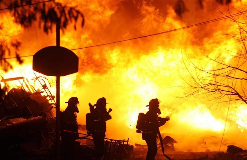 Firefighters spray water on a fire on Clarence Center Road involving an airplane and a home Thursday. New York state police say a 50-passenger commuter plane has crashed into a home in suburban Buffalo. There was no immediate information on injuries. State Trooper John Manthey says the plane hit a house in Clarence at about 10:10 p.m. Thursday.