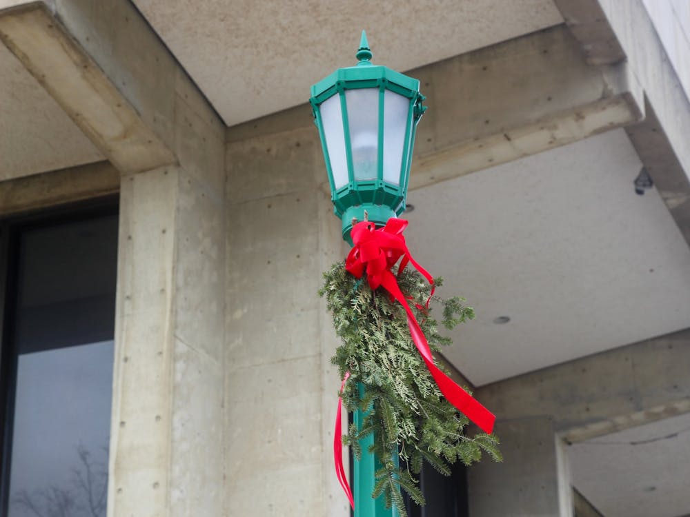 A streetlamp decked with holiday decor stands Dec. 5, 2022, near the Musical Arts Center. Street lamps all across IU’s campus are decorated for the holidays.  