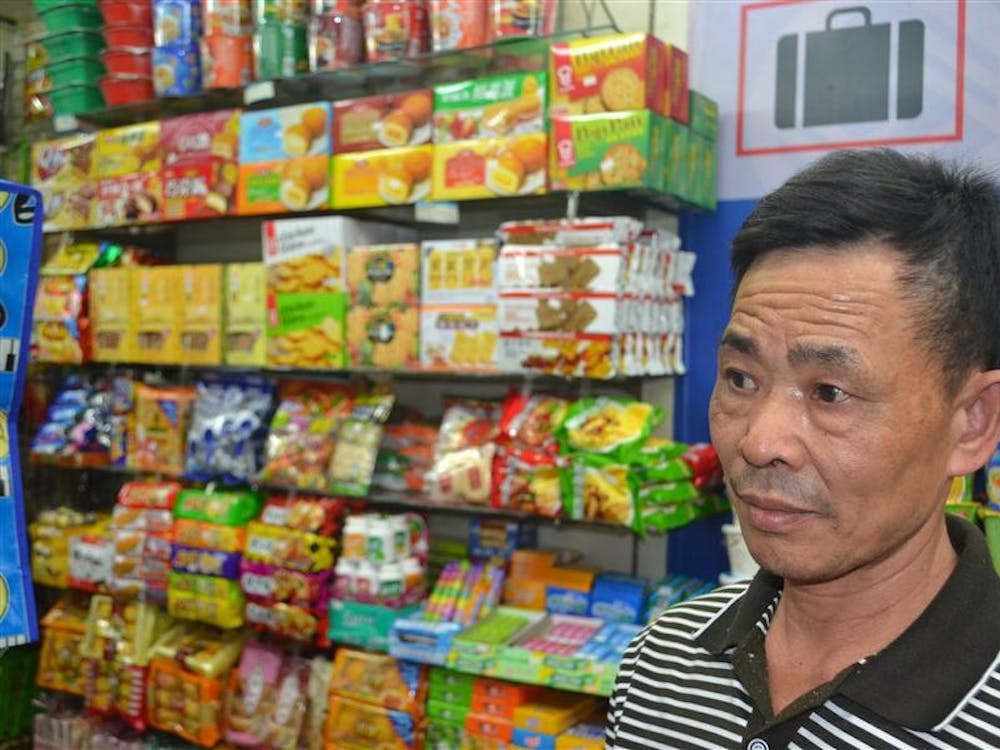 A vender sells snacks at a shop in Shenzen, China.  The snack and flavors of chips available are similar to popular Chinese dishes.  